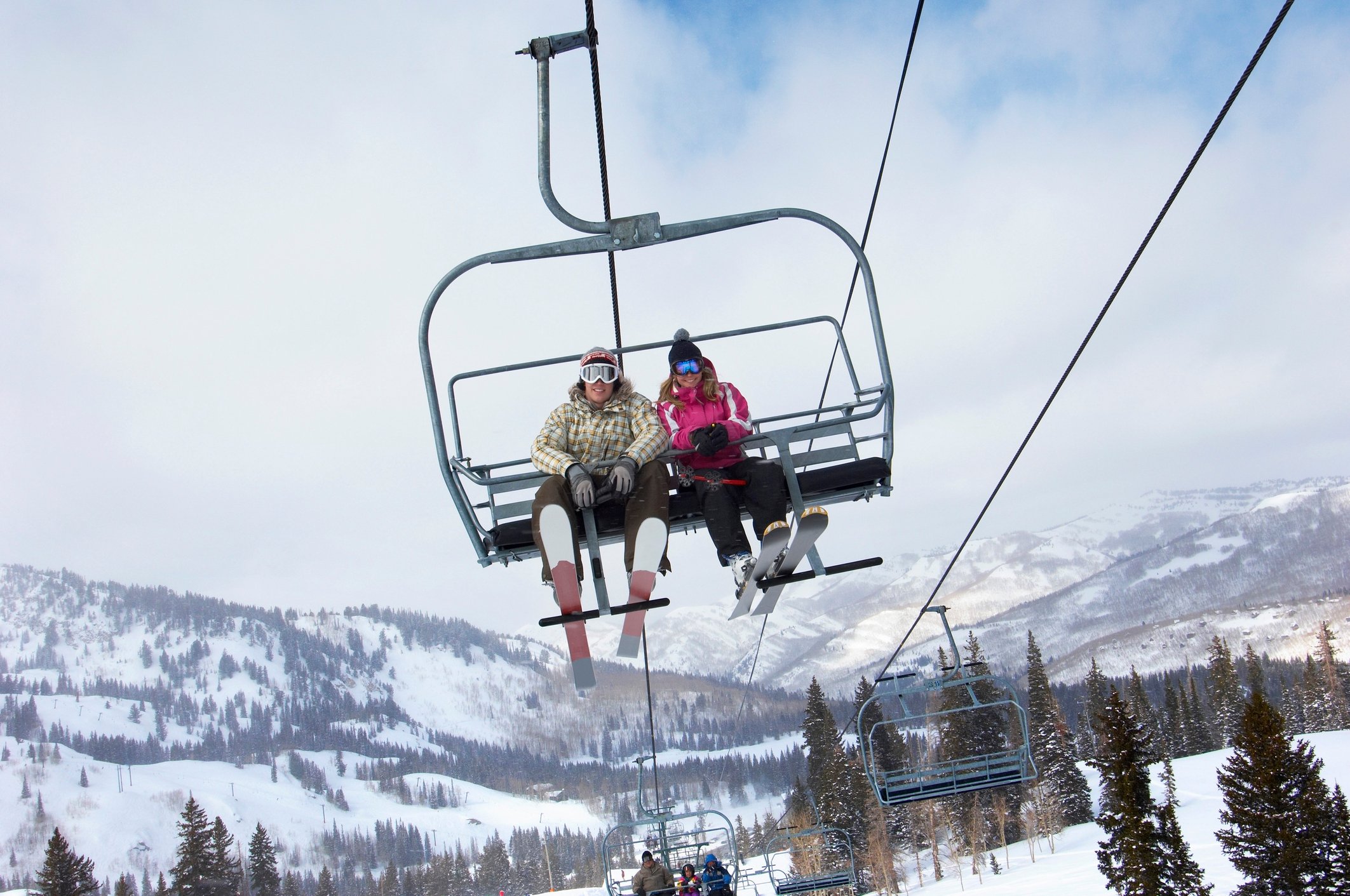 A couple riding a chairlift at a ski resort