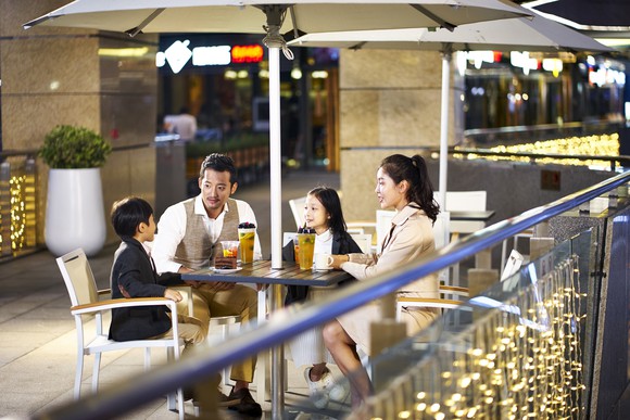 A family sits at a coffee shop.