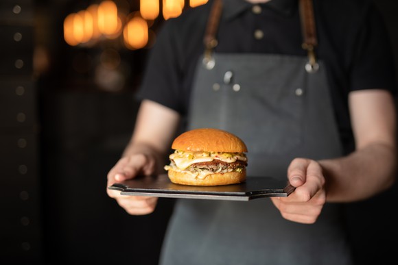 Waiter serving a hamburger