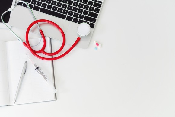 A laptop, a notepad, and a stethoscope.