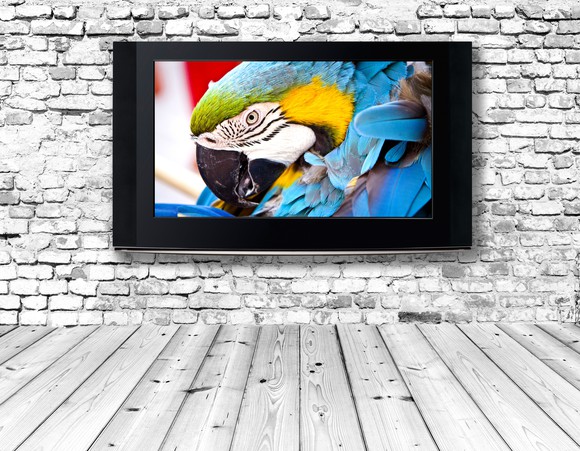 A flat-screen TV on a brick wall.