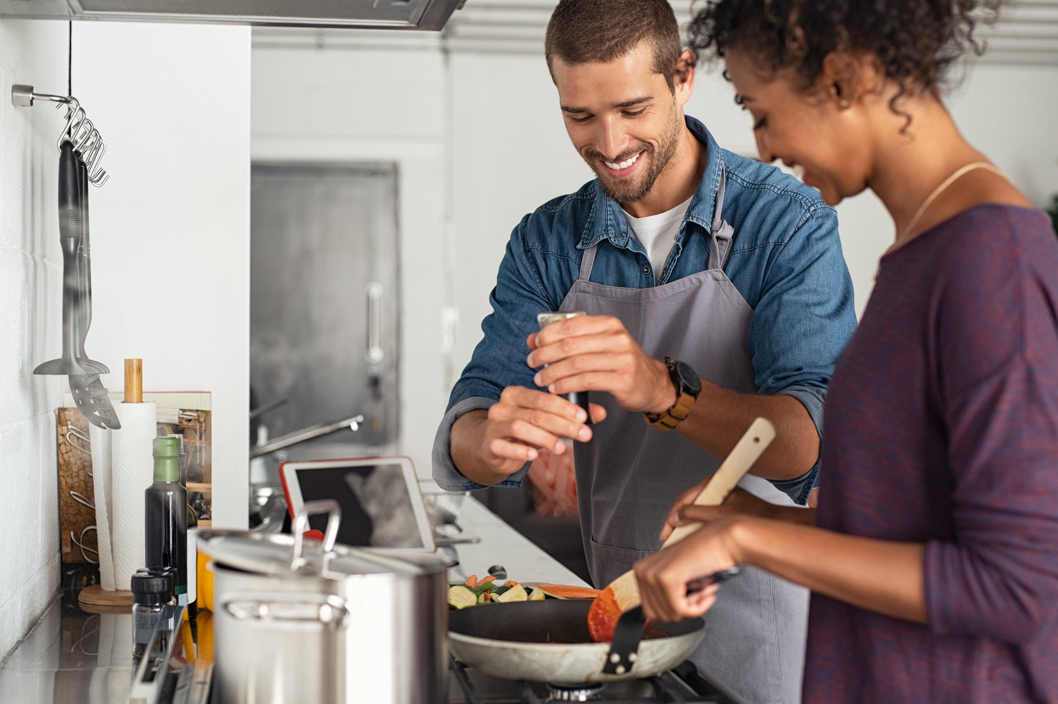 a couple cooking together over a stove