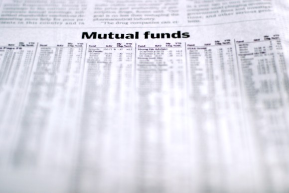 A newspaper opened to the mutual funds page with a listing of funds and performance. 