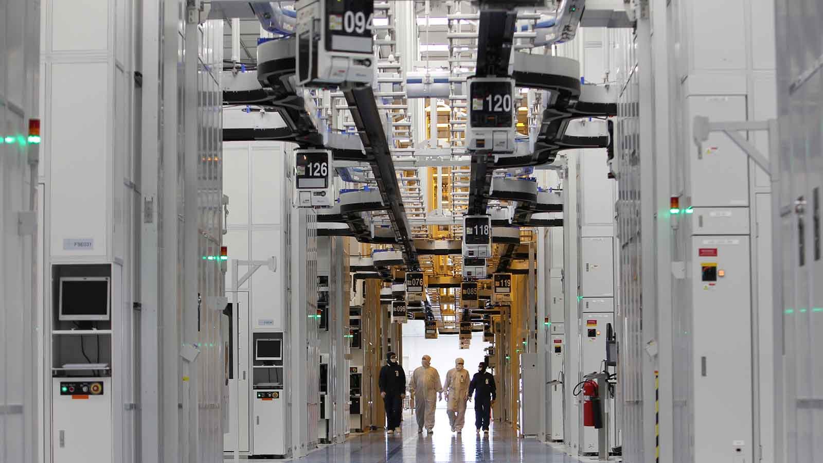 A group of people walking through a semiconductor fabrication facility.