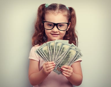Little girl fanning a wad of $100 bills