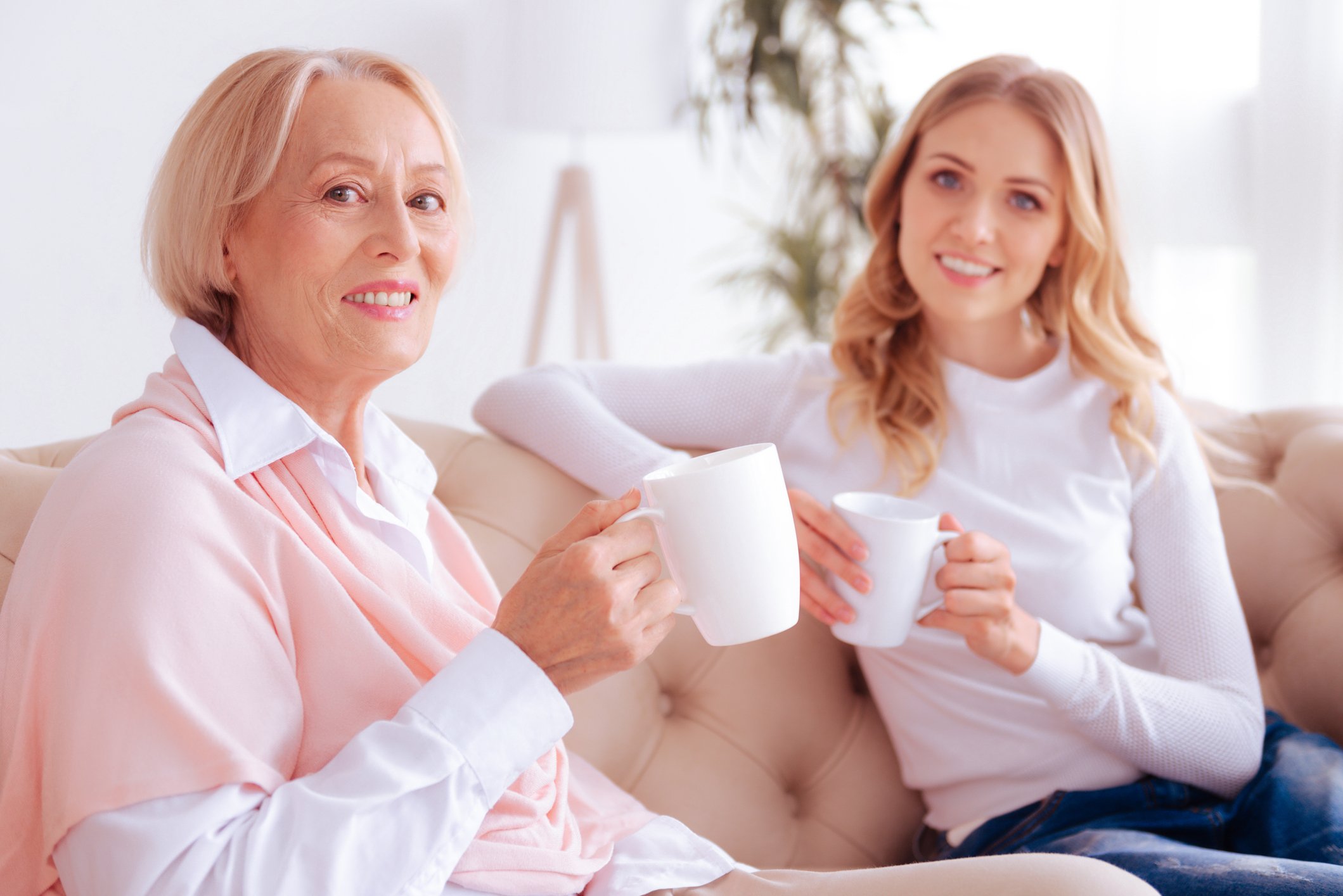 Older woman having coffee with millennial female.