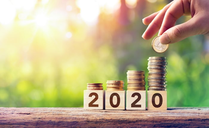 Four stacks of coins in front of 2020 -- with the stacks growing as the year ages.