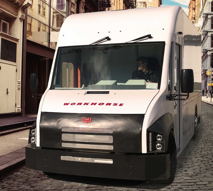 Workhorse van in a narrow alleyway with cobblestones and buildings nearby.