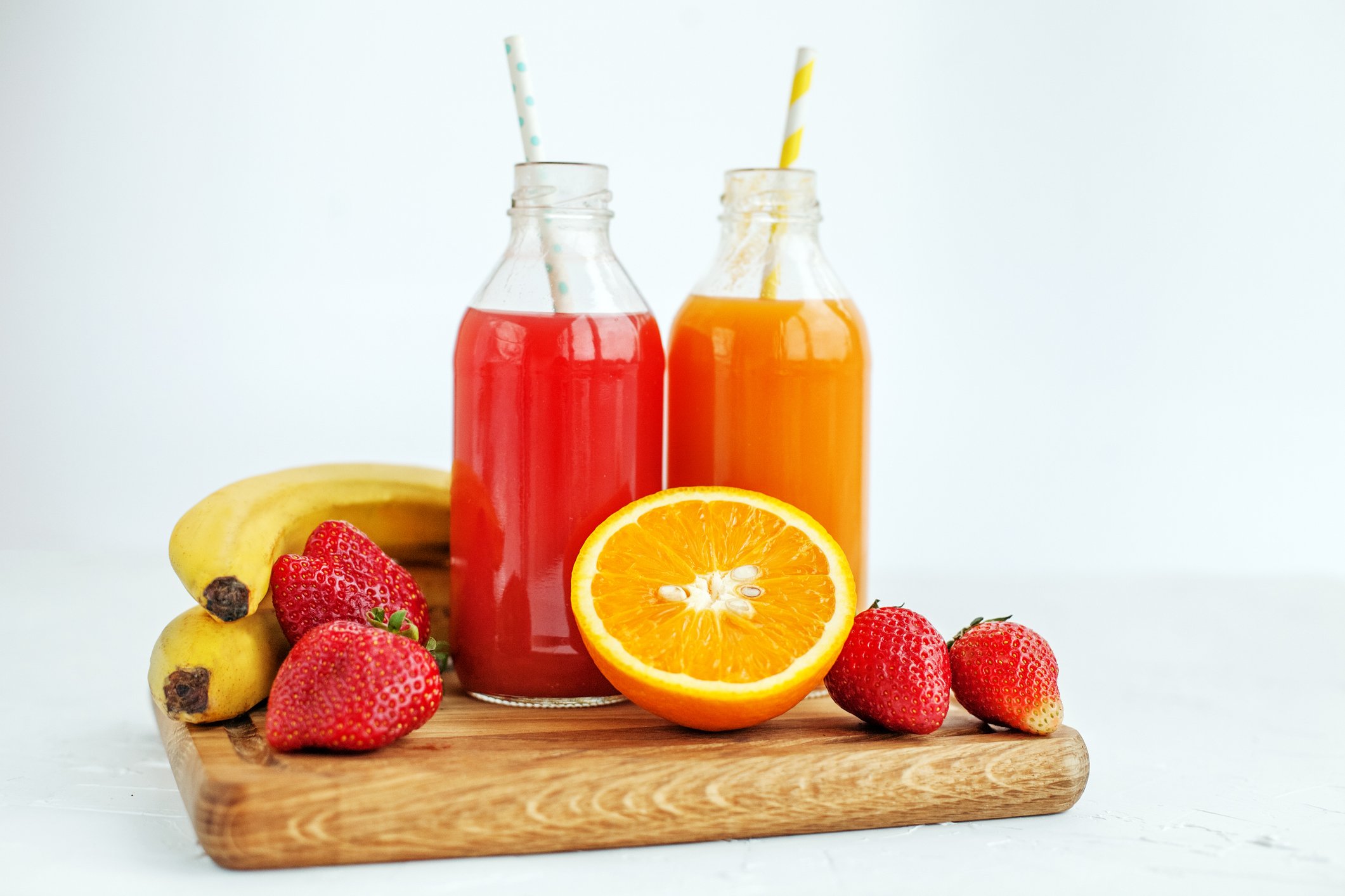 Bottled smoothies with straws and fruit