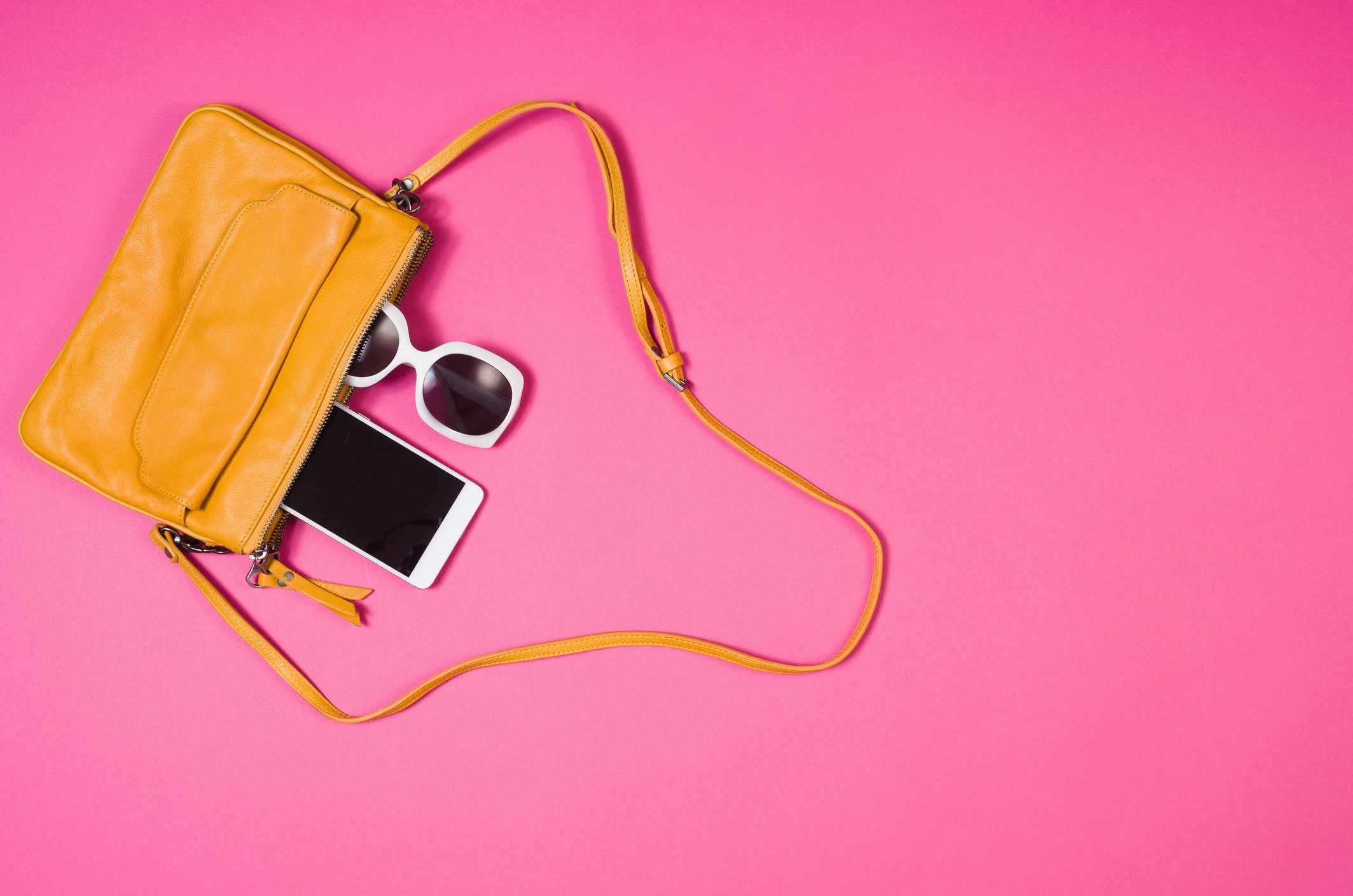 Handbag with phone and sunglasses falling out.