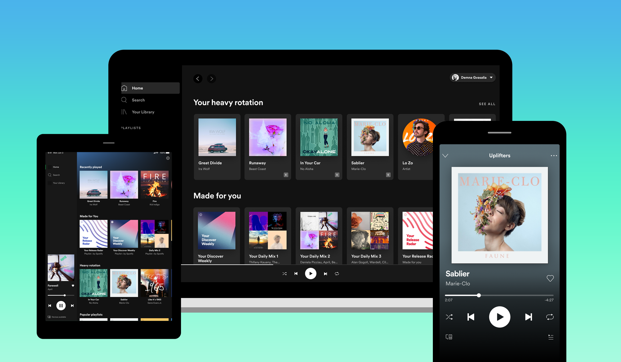 Spotify app displayed on a laptop, mobile phone, and tablet.