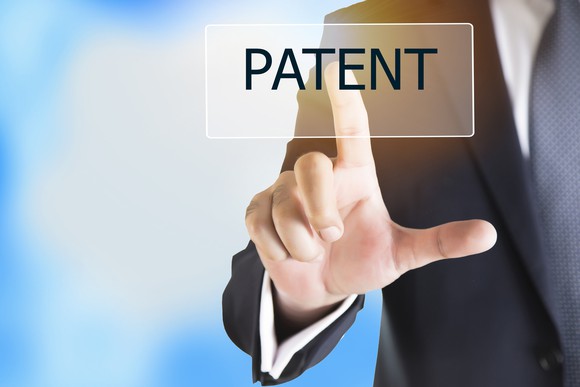 Businessman's finger pointing to the word "patent"