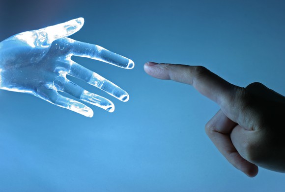 Human hand touching index finger with a virtual hand's index finger