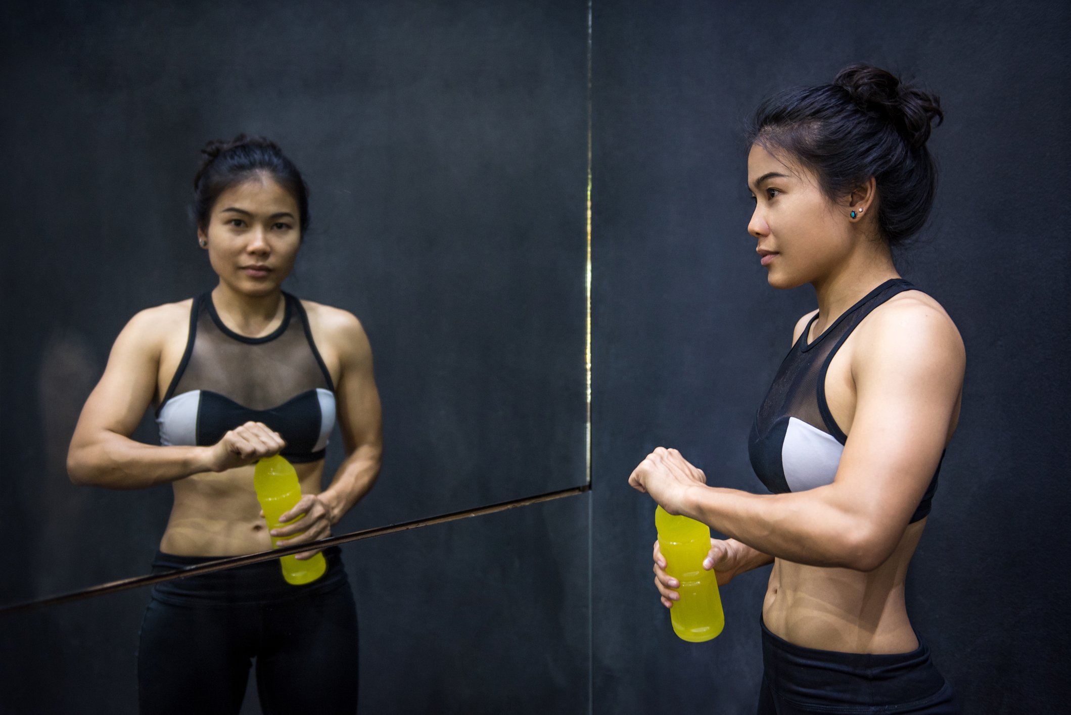 Woman taking a break from exercising in front of mirror.