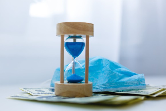 An hourglass on money.