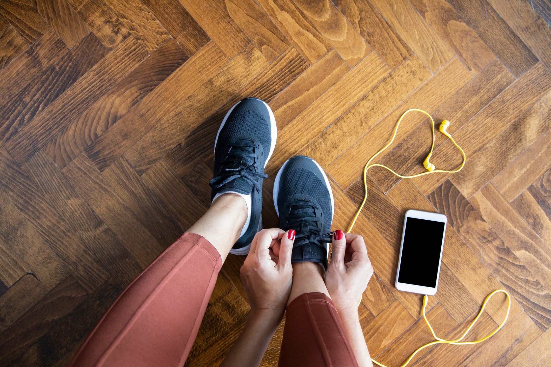 A woman tying her Nike shoes.
