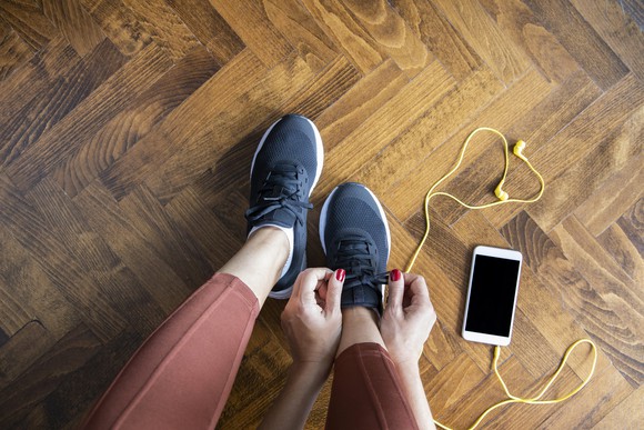 A woman tying her Nike shoes.