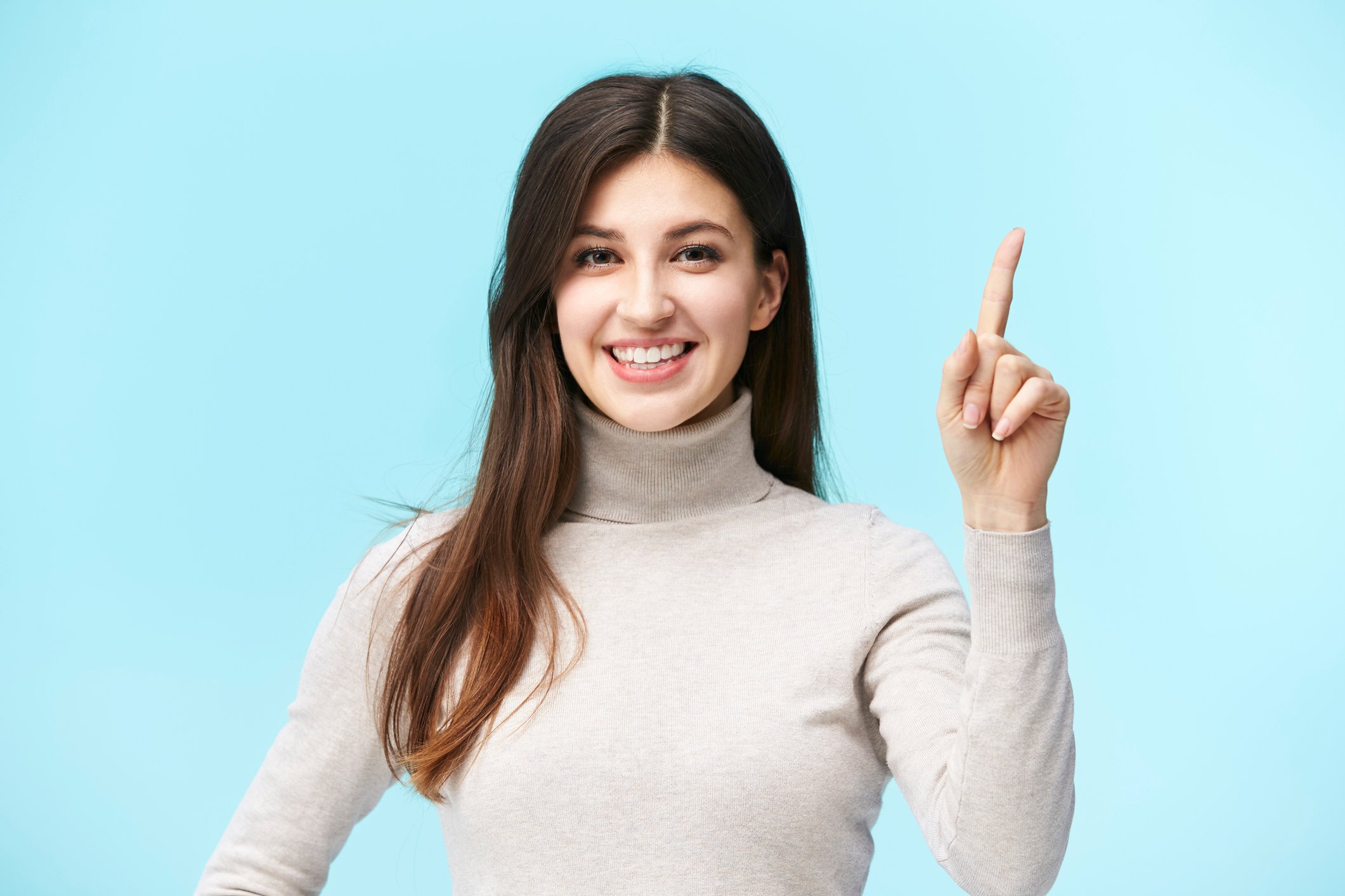 A woman holding up her index finger to signify 1
