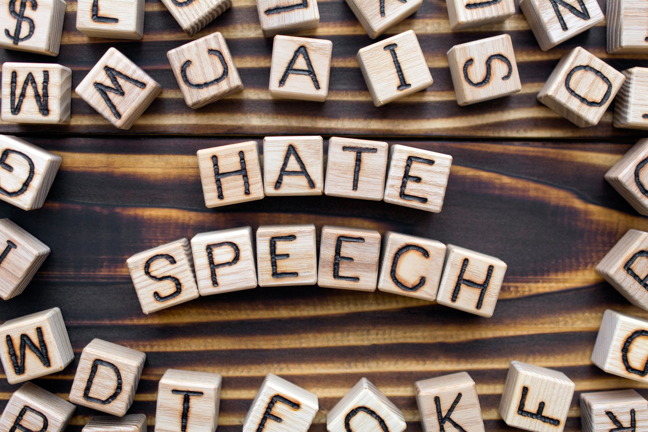 Letter blocks spelling "Hate Speech" on a table.