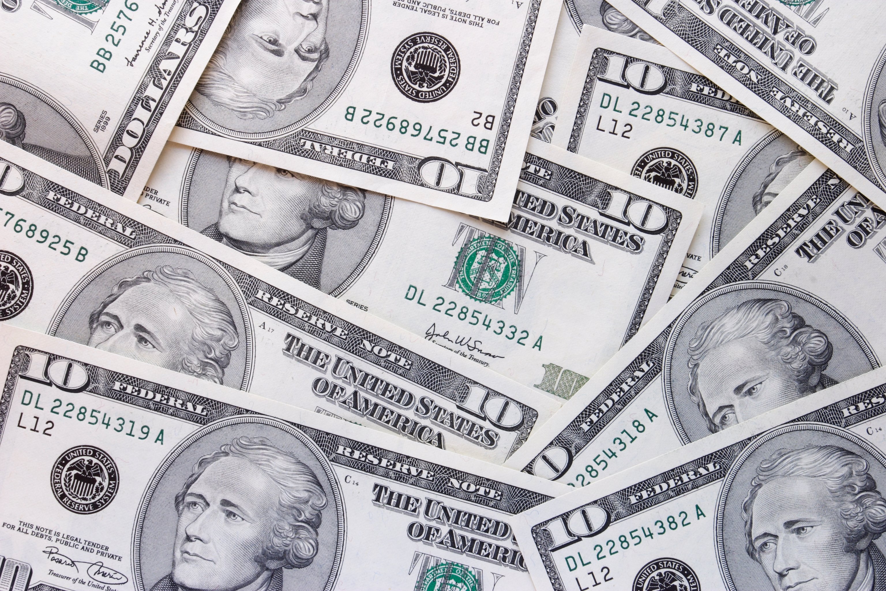 $10 bills are scattered on a surface