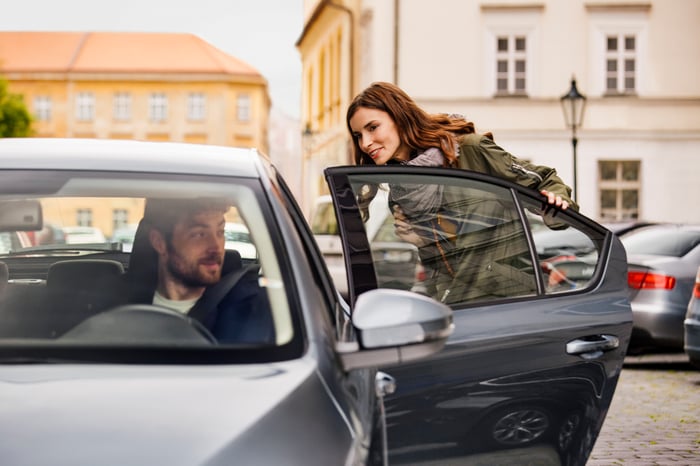 An Uber driver picks up a female passenger.