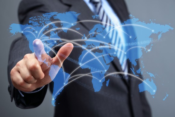 A person is pointing to a digital map of the world. 