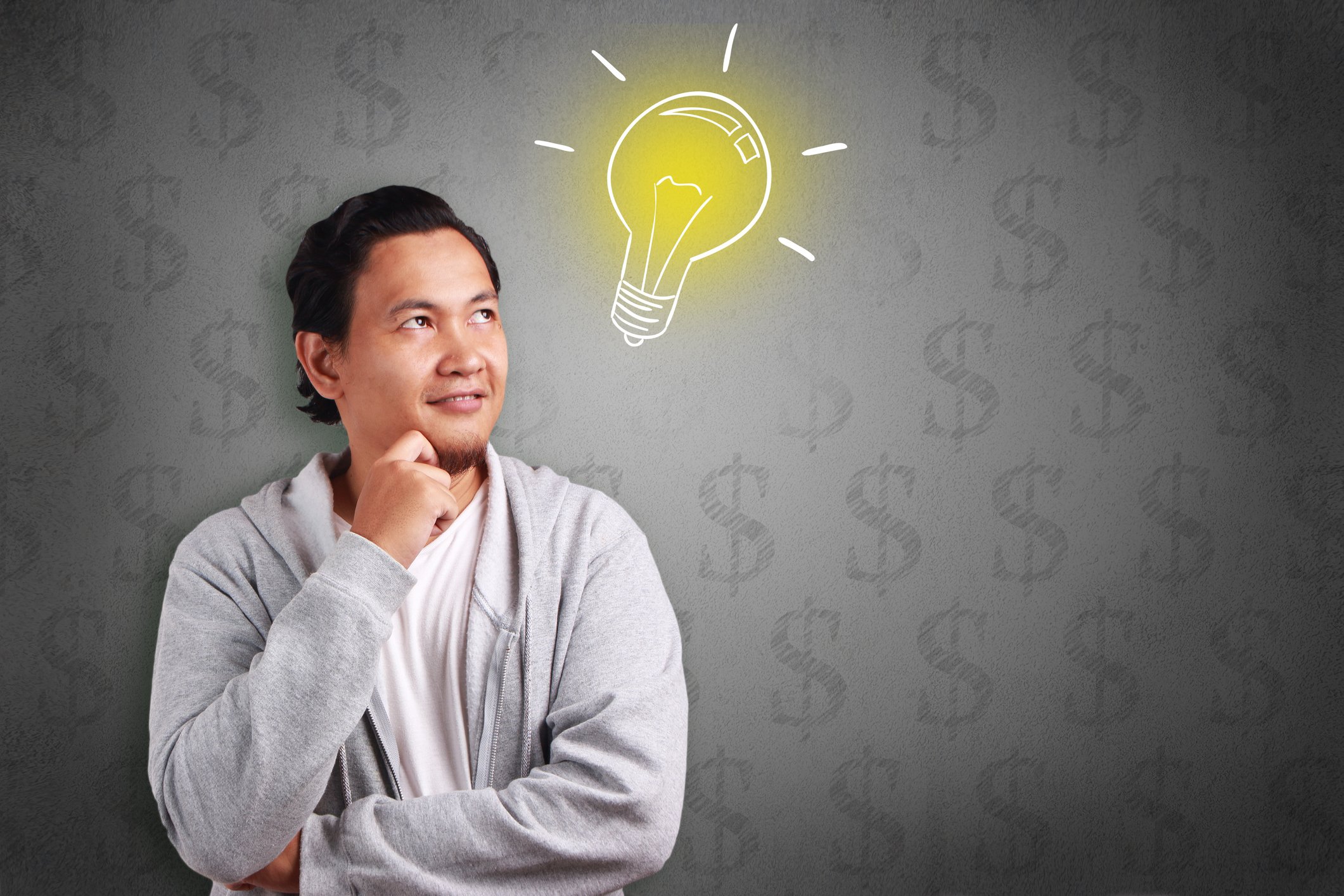 Young man with an image of a light bulb next to his head and dollar signs in the background