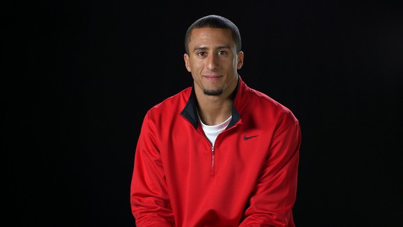 Colin Kaepernick smiling wearing a Nike jacket.