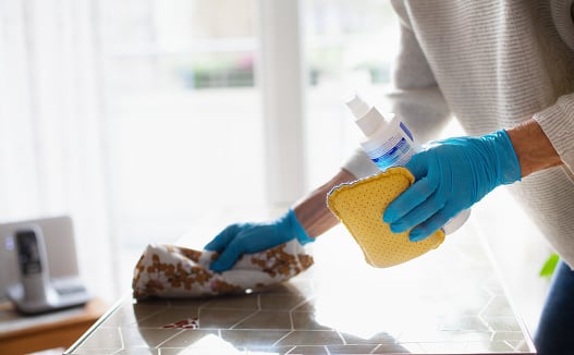Person cleaning flat surface with sponge and rag