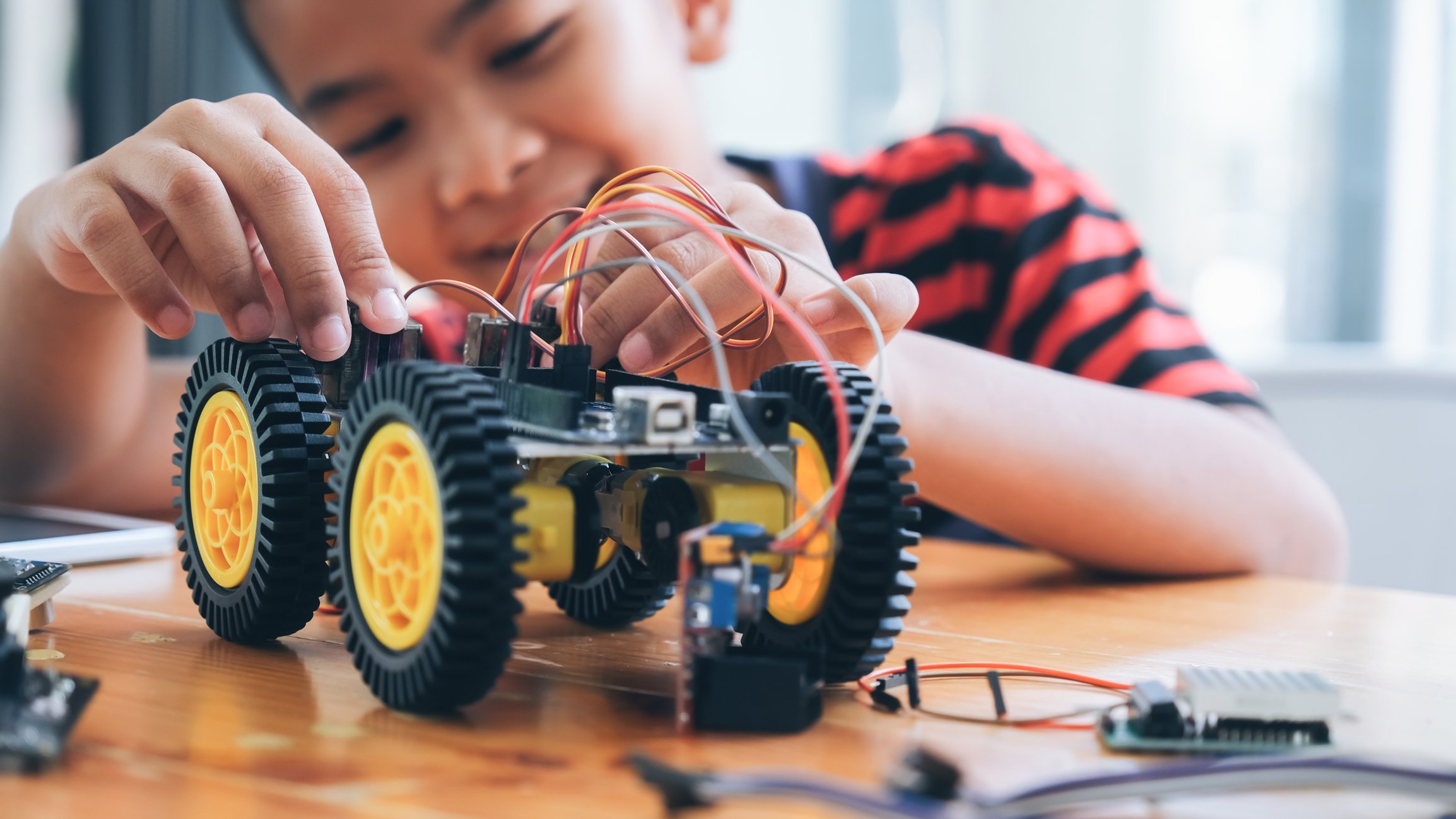 A little boy rewires a toy car. 