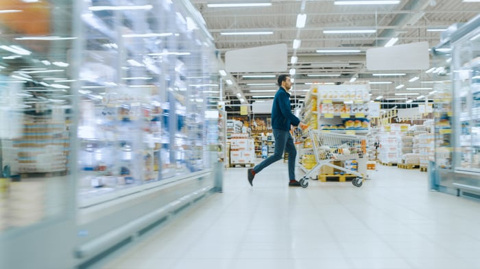 A man pushing a cart through a supermarket