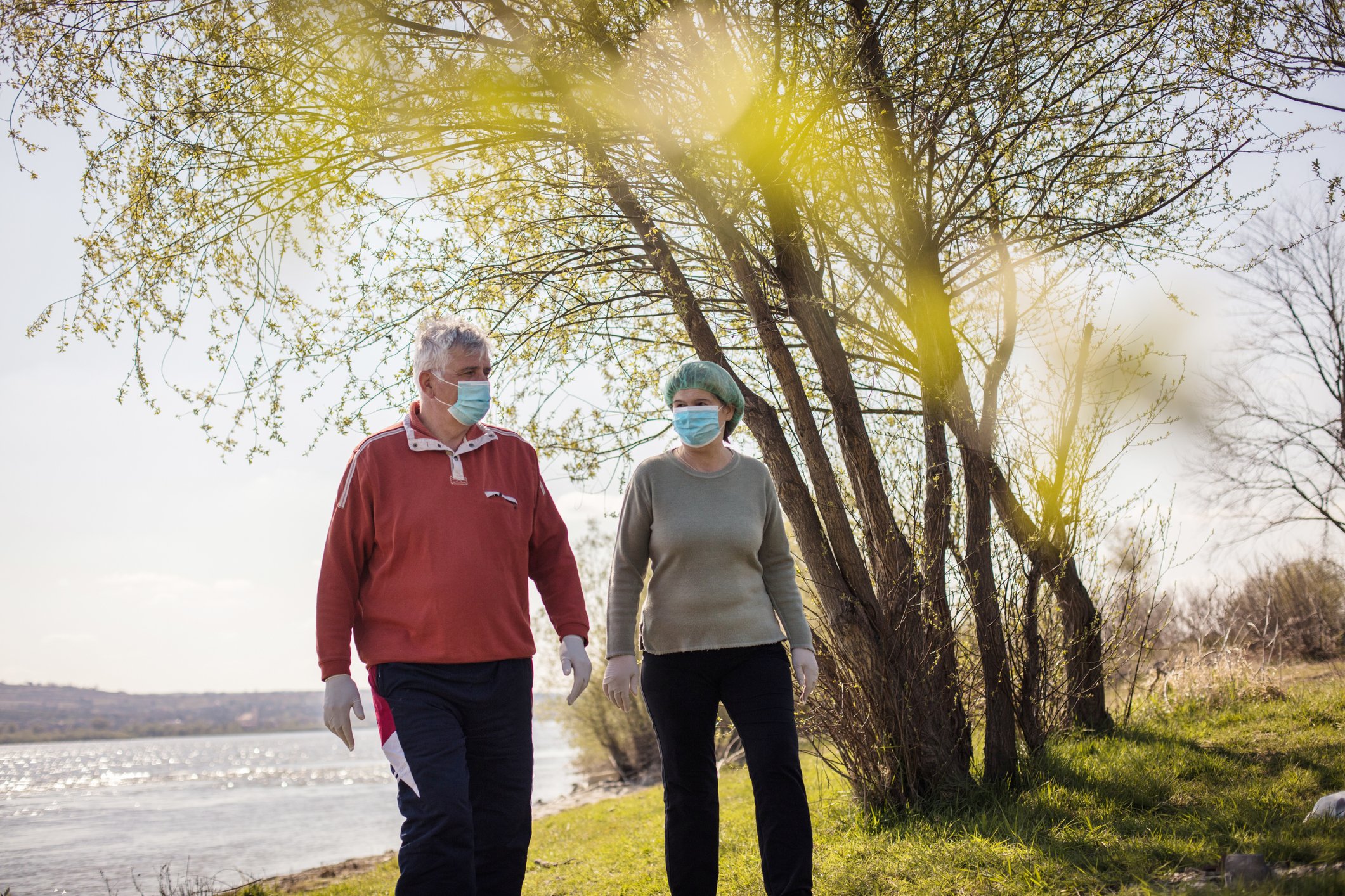 Senior couple at the park wearing masks