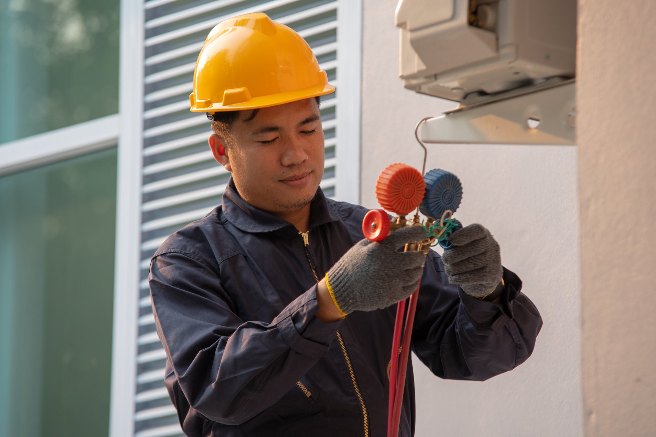 A commercial HVAC worker tests an air-conditioning and ventilation system.