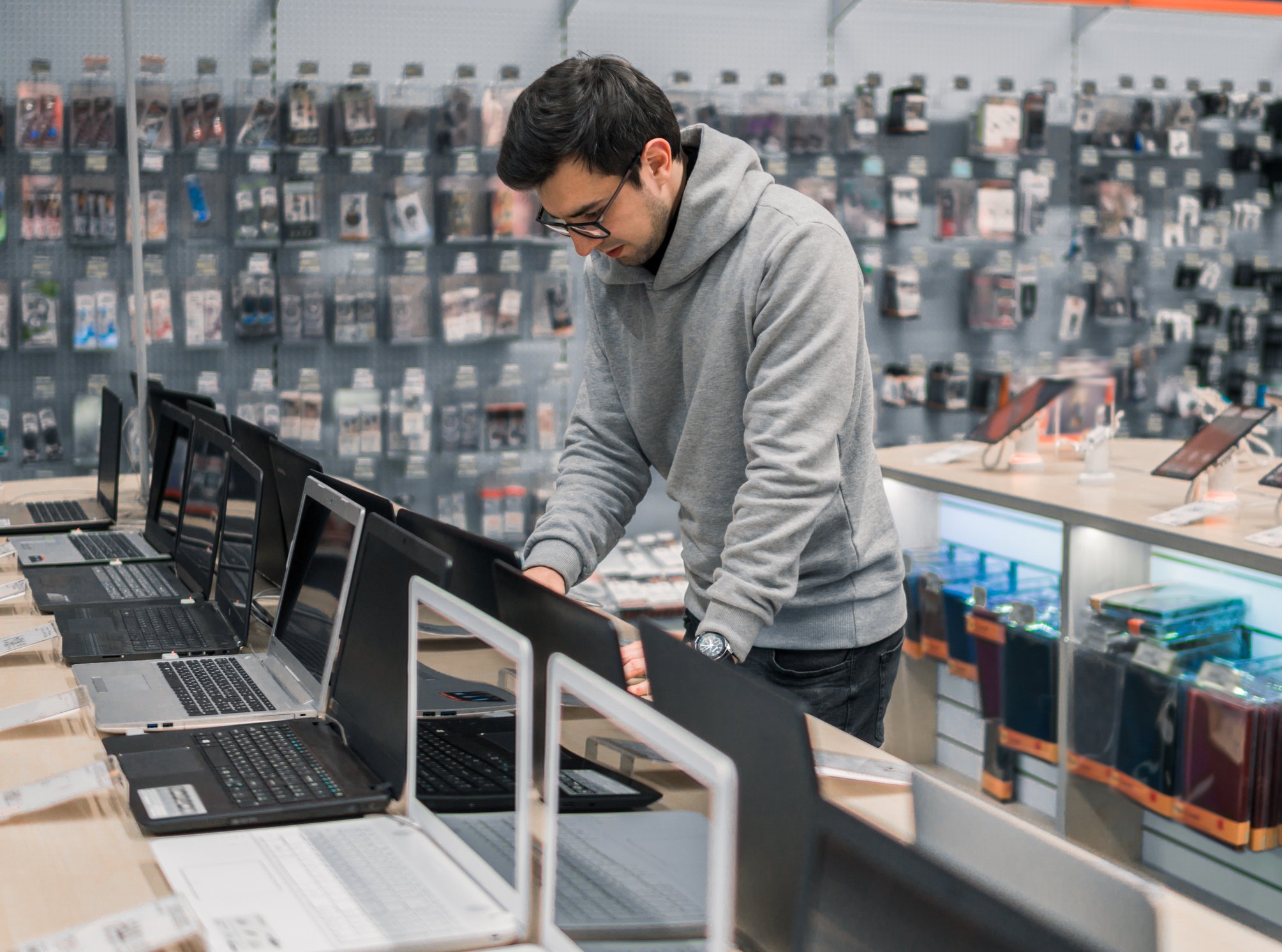 Man in store looking at row of laptops