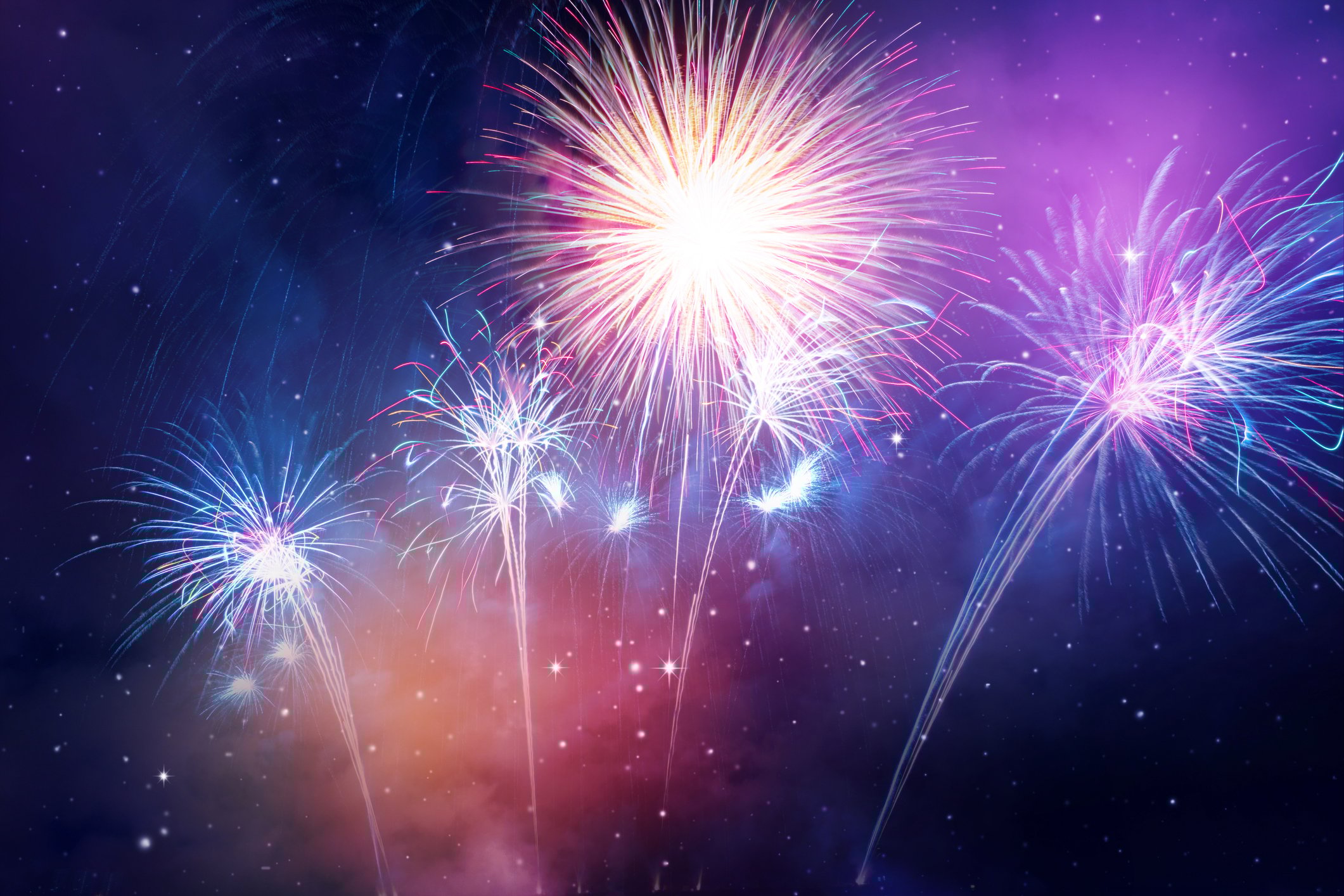 A fireworks display in purple tones is shown against a night sky.