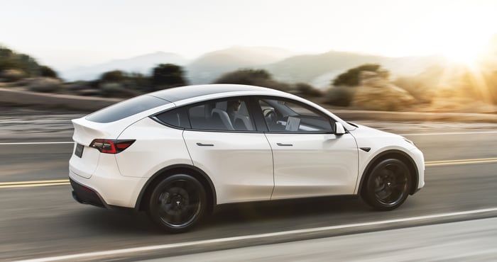 A white Tesla Model Y, an upscale electric crossover SUV.