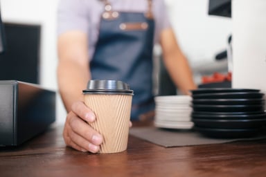 Worker in a coffee shop giving a customer a drink
