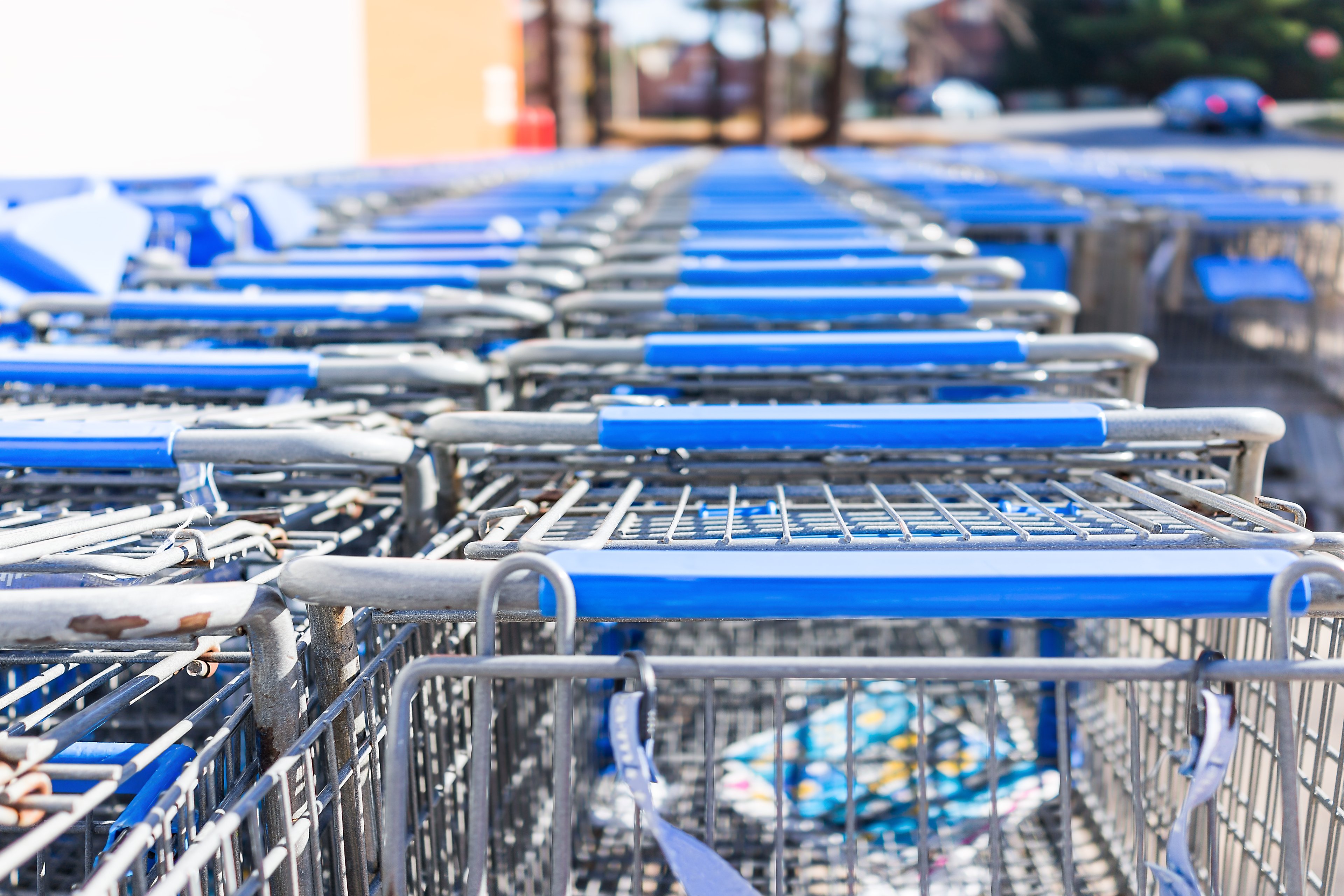 Rows of blue shopping carts outside of a store. 