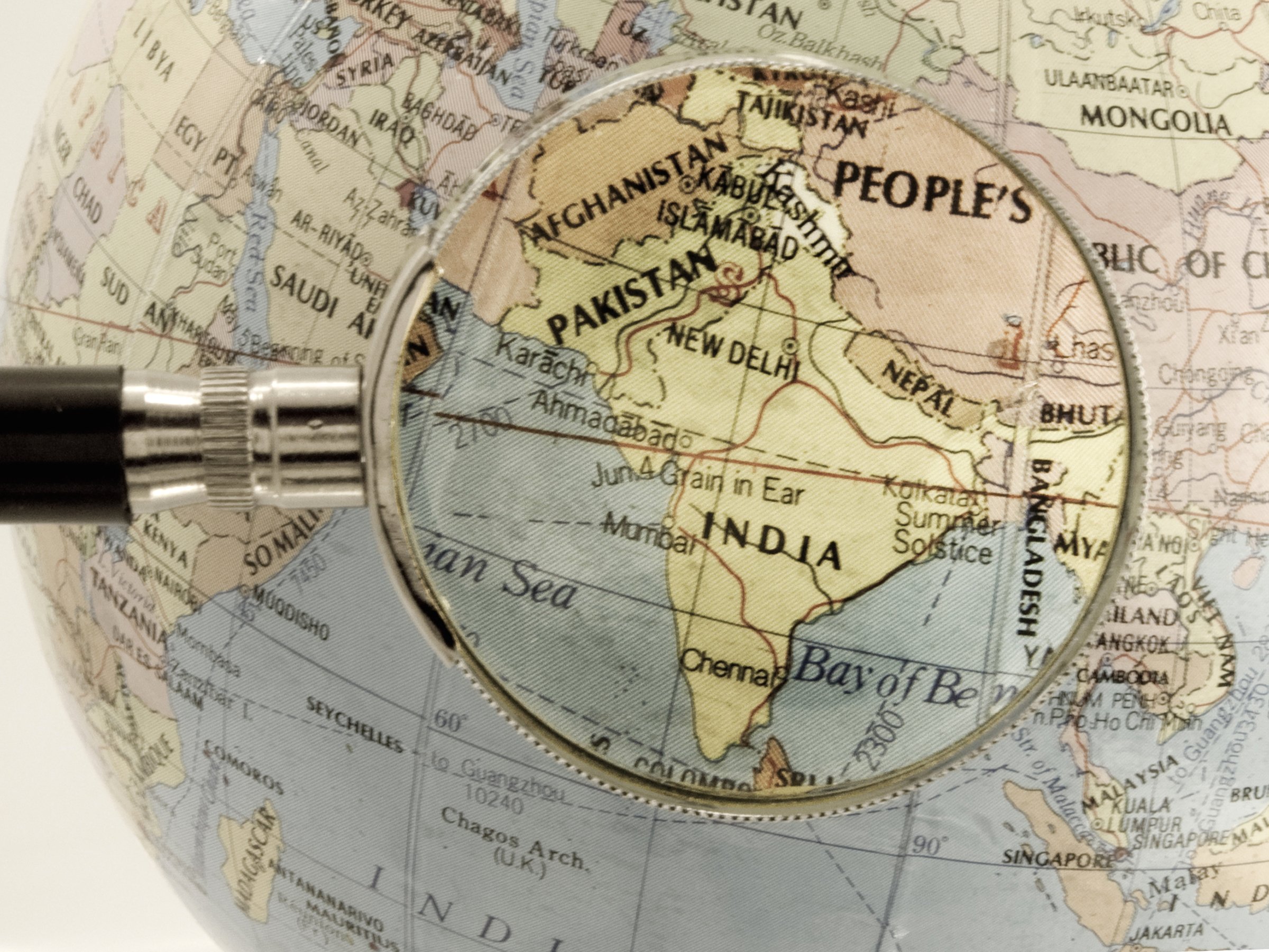 Magnifying glass held over a map of India.