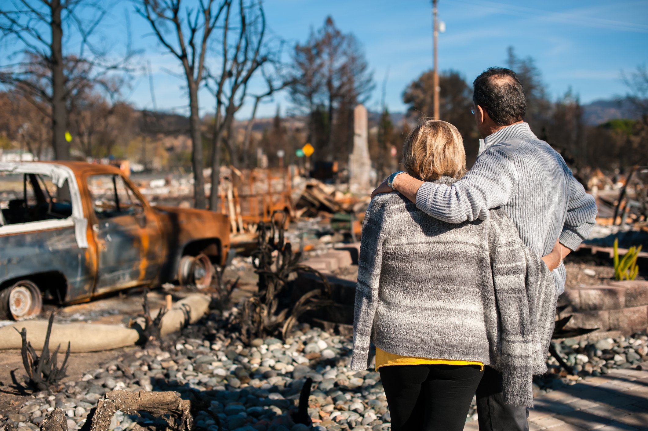 Homeowners looking at property site of a home completely destroyed by wildfire