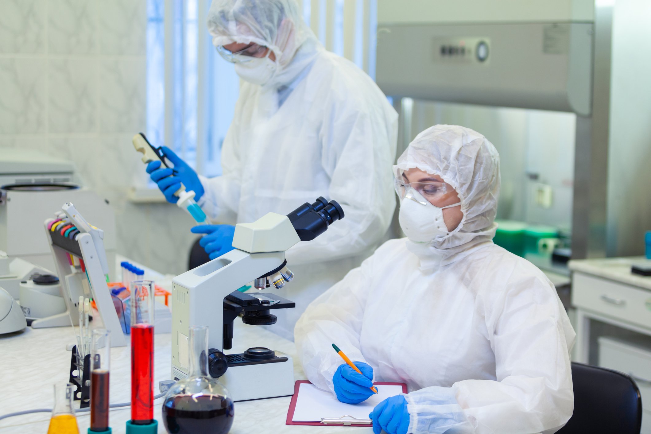 Scientists with masks working in lab. 