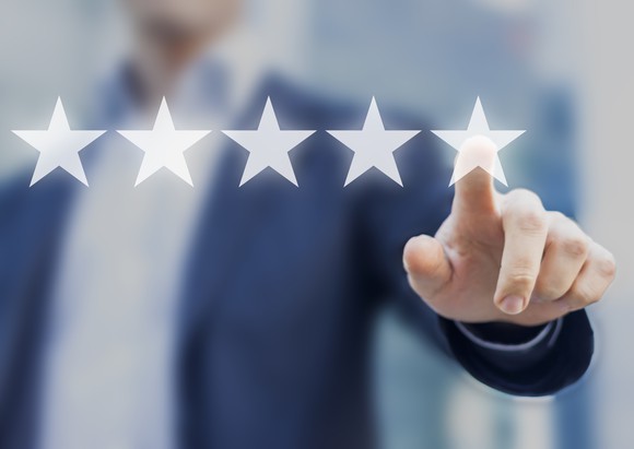 Businessman pointing to one of five stars