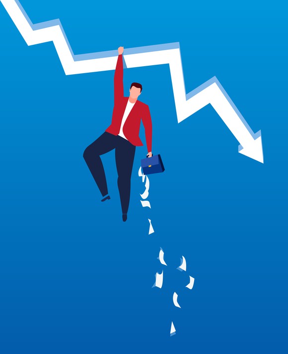 A man clings to a downward sloping arrow as files fall out of his briefcase. 