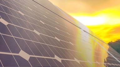 Solar panel with sun in the background