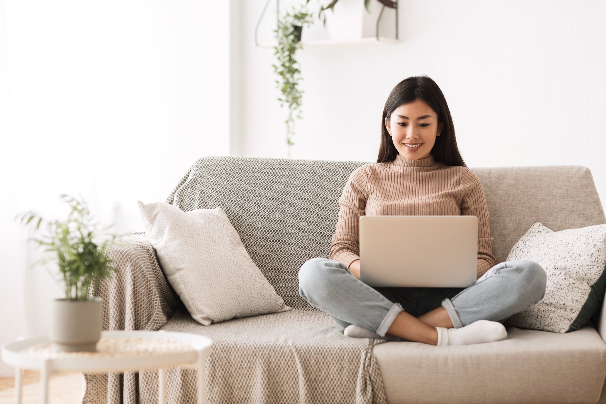 Woman sitting on  a couch with a laptop computer