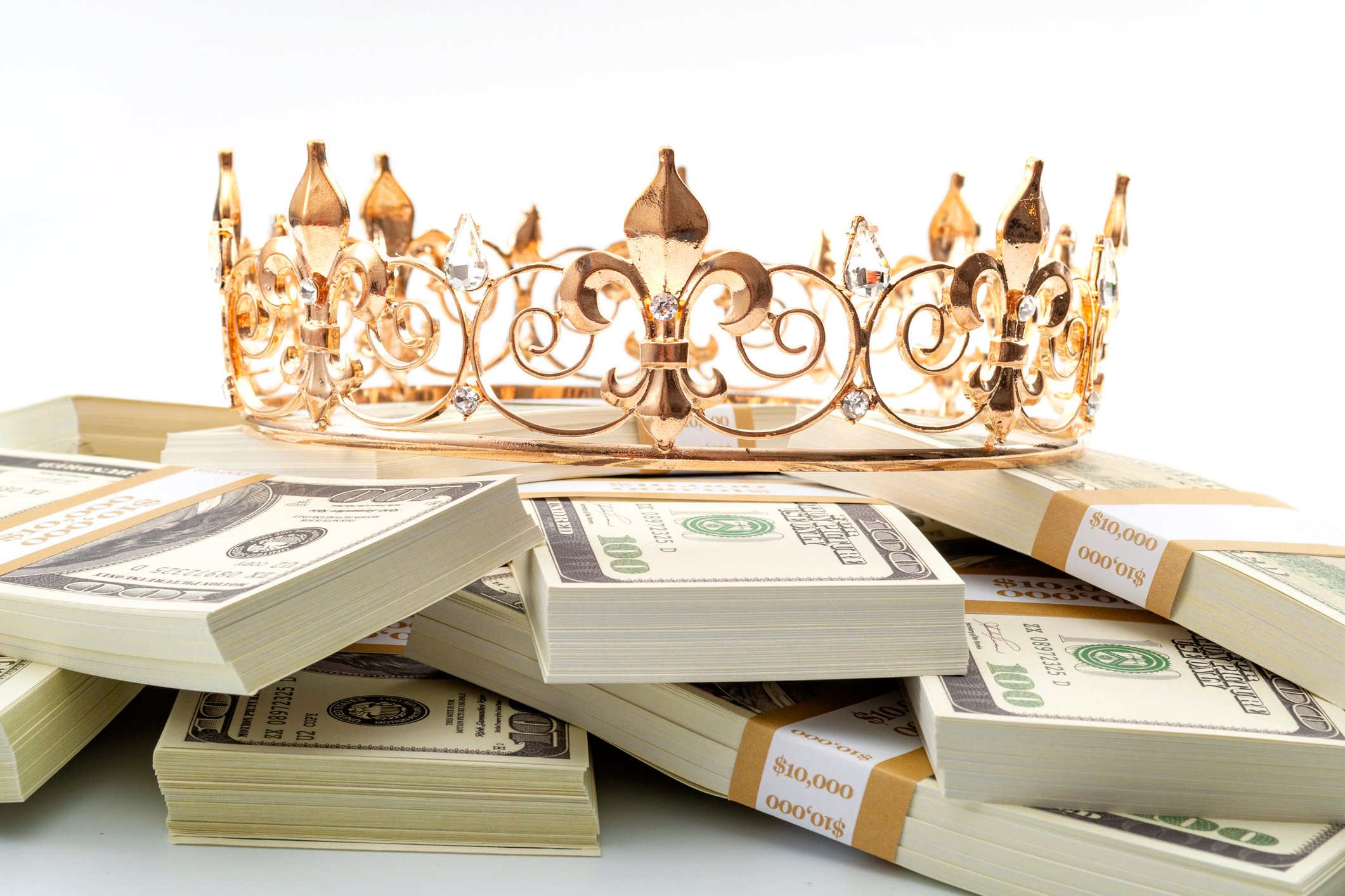 A crown sits on top of a pile of cash.