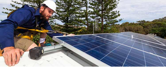 Worker installing solar panels on roof