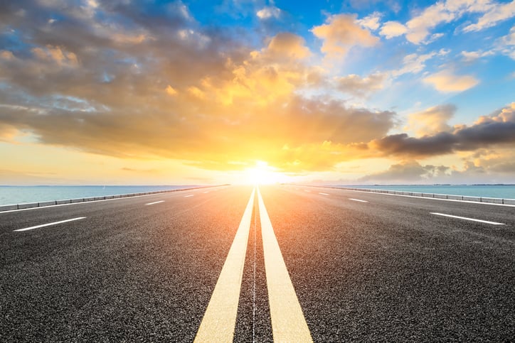 View down a roadway into a bright horizon. 