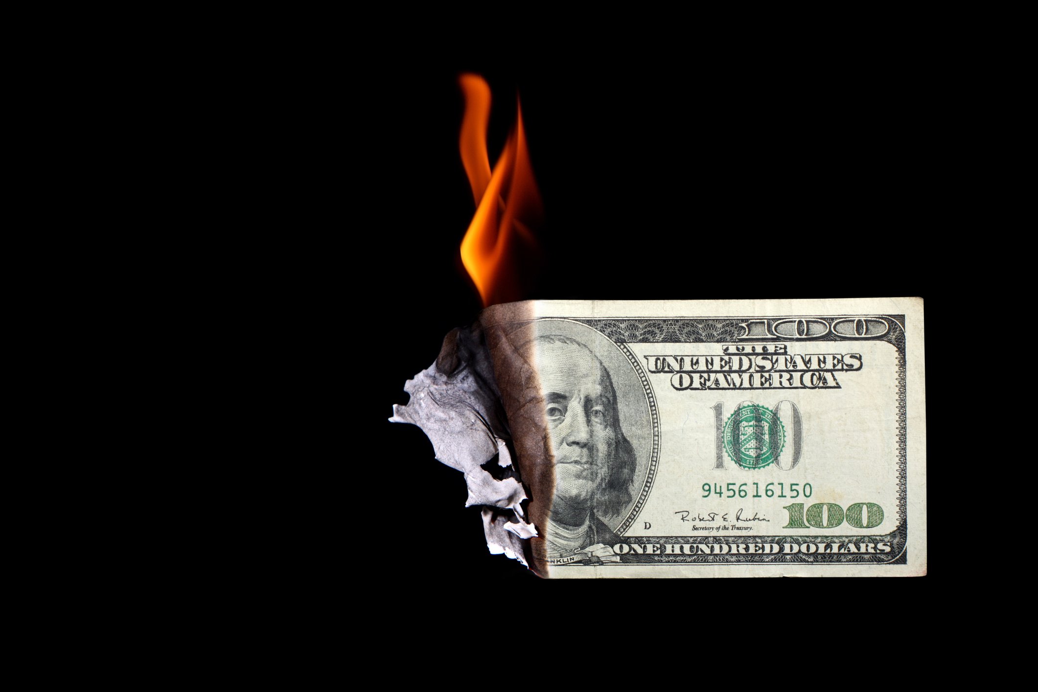 Burning hundred dollar bill. 