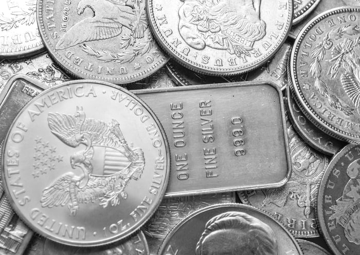 Silver coins and bars piled loosely on each other.